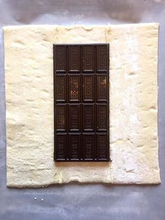 a piece of chocolate sitting on top of a white wall next to a brown window