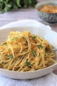 a white bowl filled with spaghetti on top of a table