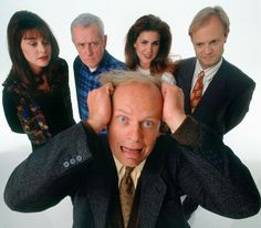 a group of people standing next to each other with one man covering his ears and the other holding his head