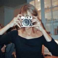 a woman holding up a camera in front of her face