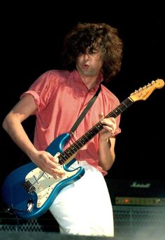 a man playing an electric guitar on stage