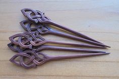 four pieces of metal sitting on top of a wooden table