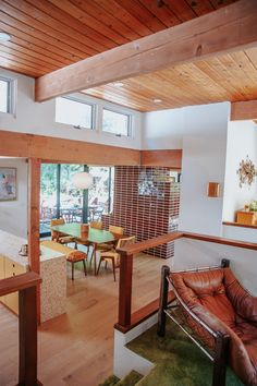 a living room filled with furniture next to a kitchen and dining room table in front of a large window