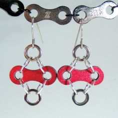 Bike chain comes in all shapes and colors these days. It's fun using a material considered industrial (bike chain) as the basis for lovely jewelry. This pair of earrings features red links (the outer plate) with a bike roller on the top and bottom. It is colorful and eye-catching, lightweight and comfortable to wear. I started out by taking a new red bike chain apart, and then thoroughly cleaning it. I just wanted a flash of color so I just used the link horizontally. It's actually 2 links back Bike Rollers, Red Bicycle, Bike Jewelry, Metal Jewelry Making, Red Bike, Bike Chain, Creative Challenge, Link Earrings, Lovely Jewellery