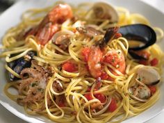 a plate of pasta with shrimp and clams