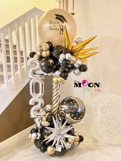 a balloon centerpiece with black, silver and gold balloons