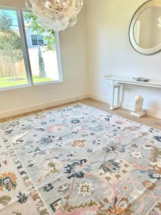 a large area rug in a room with a window and two mirrors on the wall