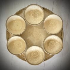 six glasses are arranged in the shape of a circle on top of a wooden table