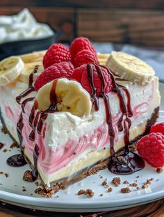 a piece of cheesecake with raspberries and bananas on top