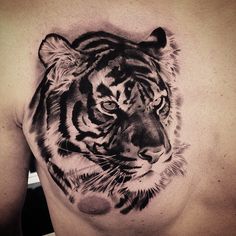 a man's chest with a tiger tattoo design on it, and the upper part of his torso