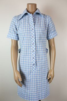 CUTE 60s 70s Westbury Fashion blue gingham shirtdress knee length / short roll-up sleeves / long pointed collar back 1/2 belt with large matching side buttons very light stain front lower right ( see photo )  no content tag but feels like cotton/poly blend ✧ NO REFUNDS ✧ PLEASE CAREFULLY CHECK MEASUREMENTS ! ✧ no size label ✧ fits like XS / S bust ✧ 18 1/2" ( laying flat ) waist ✧ 16 1/2" ( laying flat ) hips ✧ 18 1/2" ( laying flat ) back neckline to hem ✧ 36" shoulder to shoulder ✧ 14 1/2" sleeve length (rolled) ✧ 9" condition ✧ great ✧ contact me if you have any questions or want more photos ✧ also for combined shipping ✧ SMOKE FREE ENVIRONMENT ✧ Fitted Collared Gingham Dress, Fitted Gingham Dress With Collar, Retro Collared Shirt Dress For Summer, Fitted Retro Shirt Dress For Summer, Knee Length Shorts, Roll Up Sleeves, Gingham Dress, Blue Gingham, Size Label