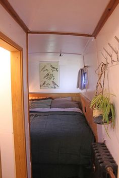 a small bedroom with a bed and plants on the wall