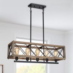 a wooden light fixture hanging from the ceiling in a room with white walls and windows