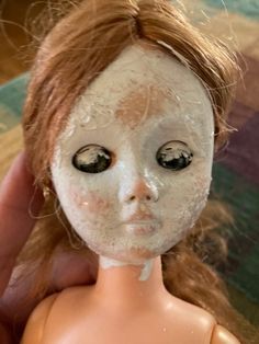 a close up of a doll's face with dirt all over it and eyes