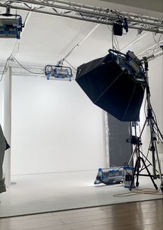 an empty photo studio with umbrellas and lighting equipment