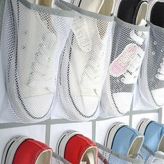 several pairs of tennis shoes hanging on a wall