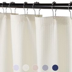 a white curtain with four different colored circles on the top and bottom, hanging from a black metal rod