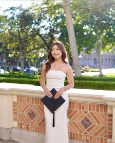 a woman in a white and black dress is posing for the camera with her hand on her hip