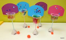 three plastic cups with straws in them sitting on a table next to some candy