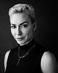 a black and white photo of a woman with blonde hair wearing a choker necklace