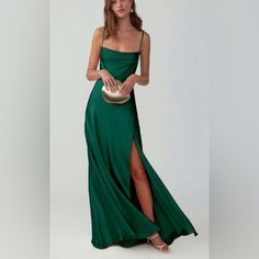 a woman in a green dress holding a gold purse