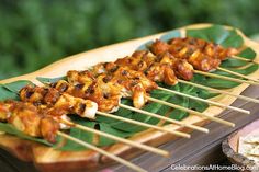 several skewers of food sitting on top of green leaves