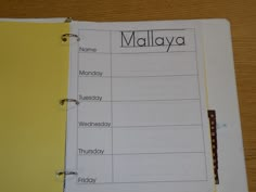 a notebook with the word malaysia written on it and a yellow binder next to it