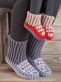 the legs of a woman wearing gray and red knitted slippers with hounds on them