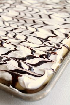 a cake with white frosting and chocolate drizzle on top