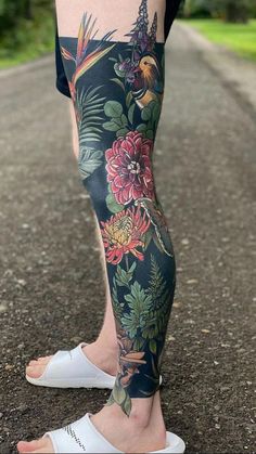 a person with tattoos on their legs standing in the road