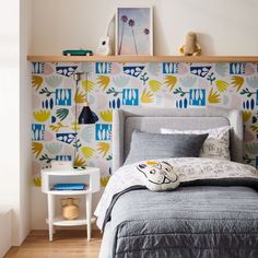 a bed sitting in a bedroom next to a wall with colorful designs on the walls