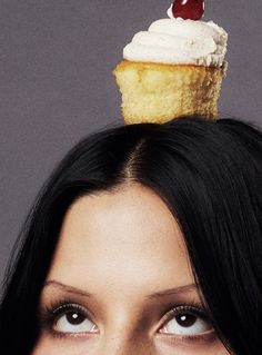 a woman with a cupcake on top of her head