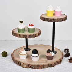 three cupcakes are sitting on two tiered trays