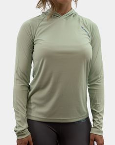 a woman wearing a green shirt and black leggings is posing for the camera