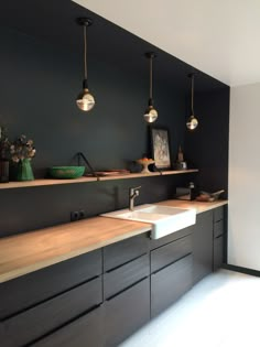 a bathroom with two sinks and hanging lights