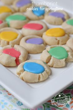 some cookies are on a white plate with colorful frosting