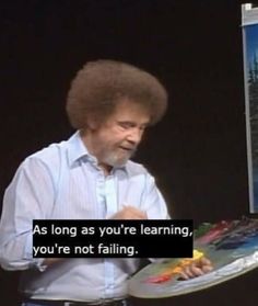 a man holding a plate with a painting on it in front of a sign that says as long as you're learning, you're not failing