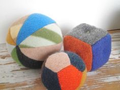 three colorful balls sitting on top of a wooden table