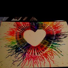 a heart made out of colored crayons on top of a table