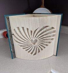 an open book that is sitting on a table with a mirror in the back ground