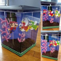 three plastic containers with some type of pixel art in them on a wooden table next to a window