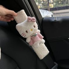 a hello kitty stuffed animal in the back seat of a car