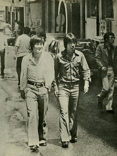 black and white photograph of people walking down the street