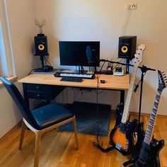 a desk with two guitars, keyboard and speakers