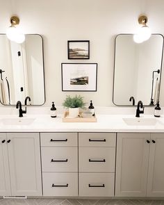 a bathroom with two sinks and three mirrors on the wall above them is decorated in black and white