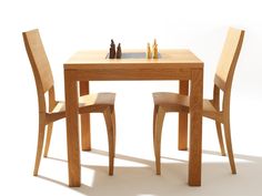 a wooden table with two chairs and a chess board on it's side, in front of a white background