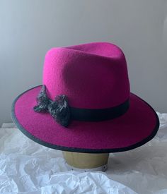 Handmade wool felt fedora hat in stunning magenta pink, finished with a unique handmade lace bow over a black ribbon. Fits an average size 57-58, but it can be adjusted on request to a slightly smaller or larger size. Elegant Adjustable Pink Fedora, Elegant Pink Adjustable Fedora, Elegant Pink Brimmed Fedora, Elegant Pink Wide Brim Fedora, Fitted Pink Brimmed Fedora, Pink Fitted Fedora For Kentucky Derby, Pink Fitted Brimmed Fedora, Winter Party Hats With Bow, Pink Short Brim Felt Hat For Winter