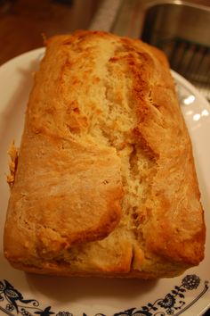 a loaf of bread sitting on top of a blue and white plate next to a fork