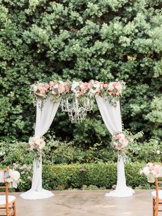 an outdoor ceremony setup with chandelier and flowers