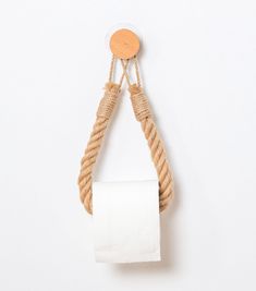 a roll of toilet paper hanging from a rope with a wooden button on the end